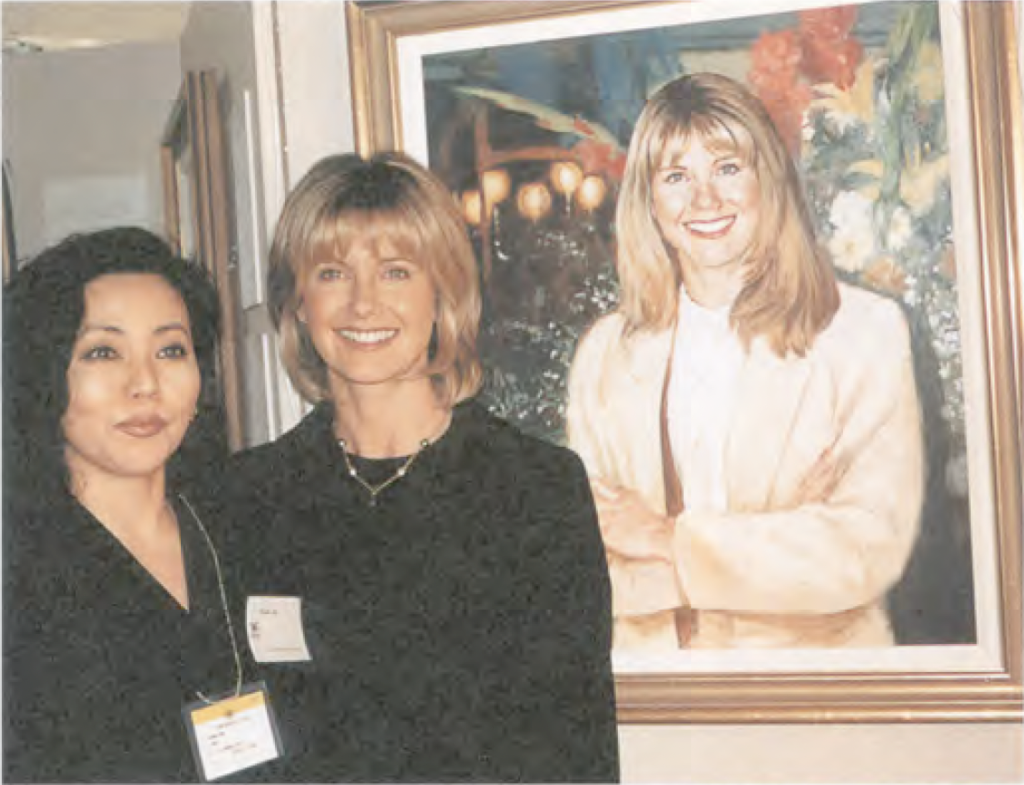 〔写真キャプション〕オリビア・ニュートンジョンの肖像画の前でオリビア本人と小野さん